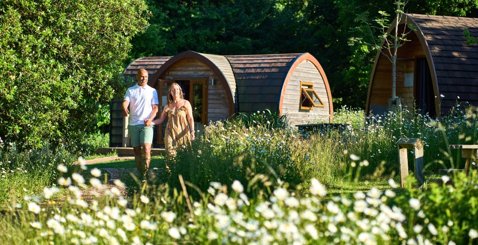 Couple walking from a Whitemead Forest Park glamping pod