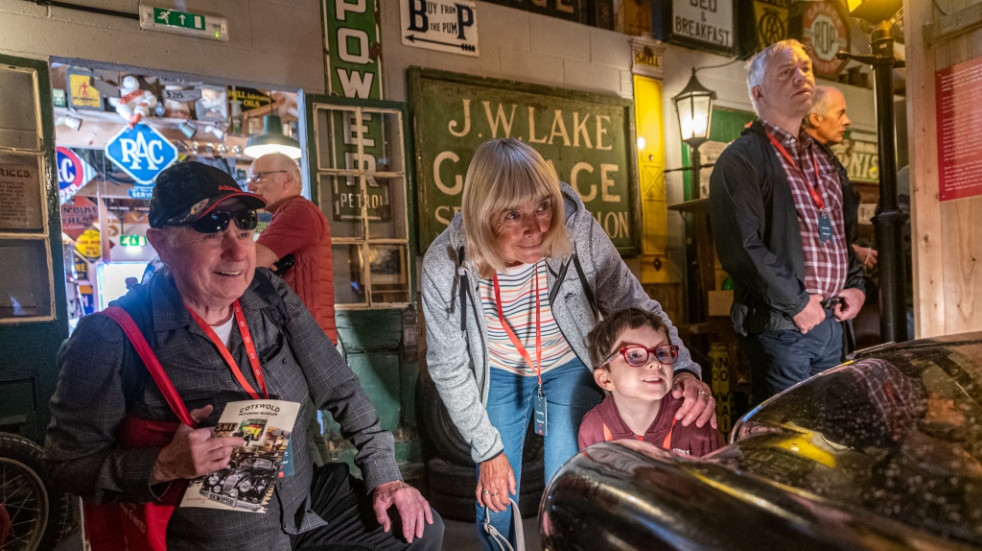 Grandparents and child looking at classic cars