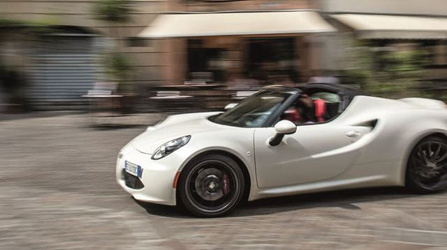 Alfa 4C Romeo Spider driving through a town