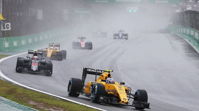 F1 cars racing around the corner of a track