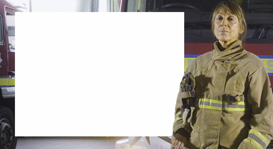 Firefighter standing on front of fire engine
