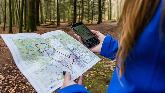 Women tracking her route on map and phone 