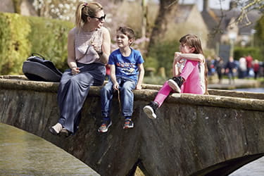 Family sitting on a footbridge Cotswolds