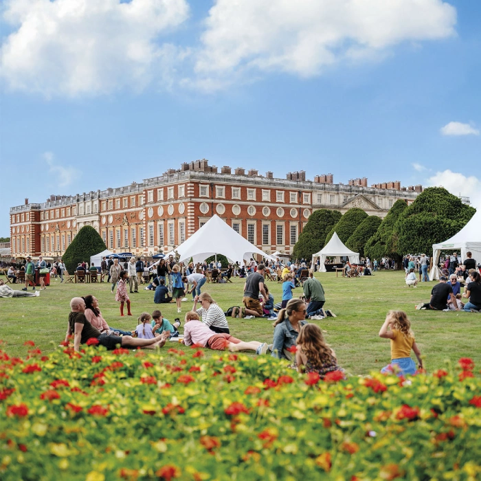 Festival visitors relaxing on the lawn at Hampton Court Palace