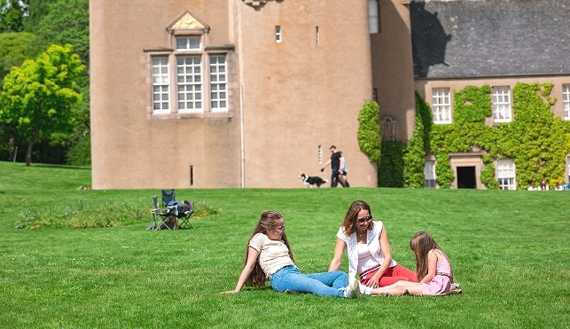 Family sitting outside a castle in Scotland