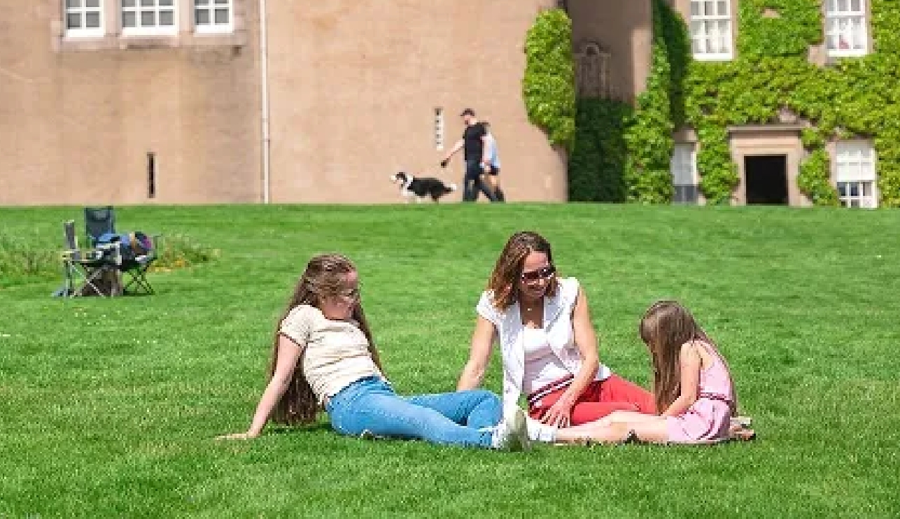 Family sitting outside a Scottish castle